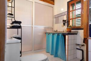 a bathroom with a shower and a blue shower curtain at Casa Los Pinos in Agüimes +17 photos