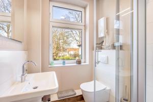 a bathroom with a toilet and a sink and a window at Ferienwohnung am Wall in Soest