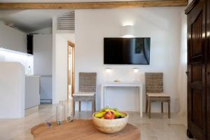 a living room with a bowl of fruit on a table at Casa Le Rocce San Pantaleo in San Pantaleo