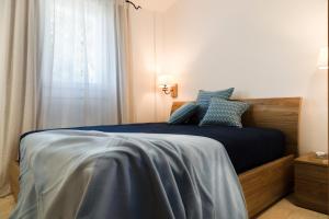 a bedroom with a bed with blue sheets and a window at Casa Le Rocce San Pantaleo in San Pantaleo +27 photos