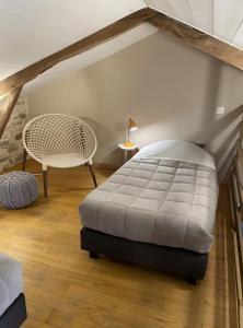 a bedroom with a white bed and a chair at Chambres D'hôtes du Pentadou in Felzins