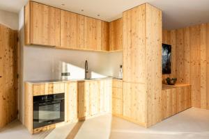 a kitchen with wooden cabinets and a stove at Vronis Lodge in Hart im Zillertal