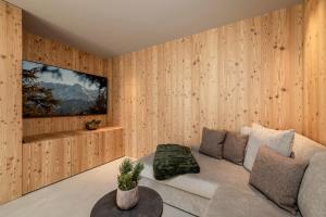 a living room with wooden walls and a couch at Vronis Lodge in Hart im Zillertal