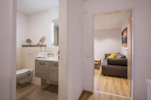 a bathroom with a sink and a toilet and a couch at Ferienwohnung Nr 5 Sonnenschein in Höchenschwand +17 photos