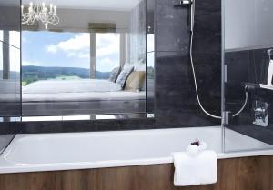 a bathroom with a glass shower and a bed at Panorama Atemlos Kuckucks Chillout in Oberibach +31 photos