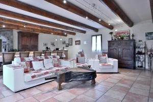 a living room with white couches and a table at Les Hélianthèmes in Guchen
