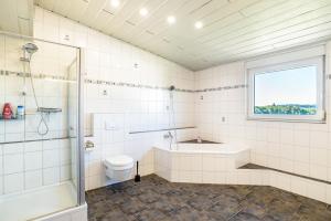 a bathroom with a tub and a toilet and a shower at Hügelblick Oase in Kraichtal +27 photos