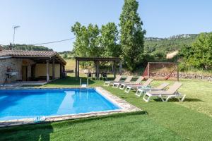 a pool with lounge chairs and a gazebo at Masia Caltiku in Els Ranxos de Bonany