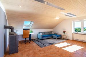 a living room with a blue couch and a table at Hügelblick Oase in Kraichtal
