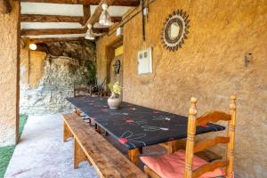 a dining room with a table and a bench at Masia Caltiku in Els Ranxos de Bonany