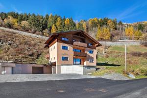 a house on a hill next to a road at Chalet Serenella in Valdidentro