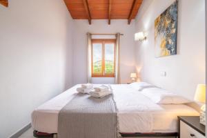 a bedroom with a bed with white sheets and a window at Can Jaume Des Carritxó in Felanitx +19 photos