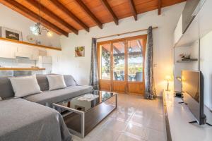 a living room with a couch and a tv at Can Jaume Des Carritxó in Felanitx