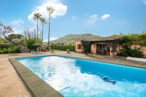 a swimming pool in front of a house at Can Jaume Des Carritxó in Felanitx