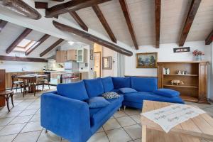 a living room with a blue couch and a kitchen at Au Petit Chevrot - Classic in Aosta