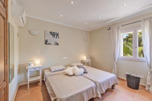 a bedroom with a bed with a teddy bear on it at Villa Es Ratolí in Cacla D'or +20 photos