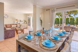 a dining room with a long wooden table with chairs at Villa Es Ratolí in Cacla D'or