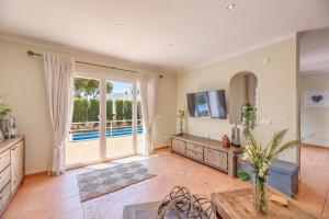 a living room with a large window and a television at Villa Es Ratolí in Cacla D'or