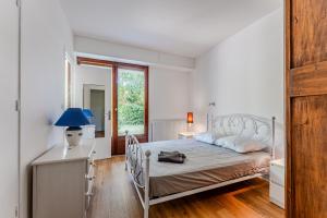 a bedroom with a bed and a table with a lamp at Appartement Rose Mousse - Abatilles in Arcachon
