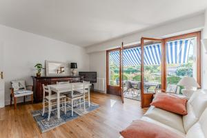 a living room with a couch and a table at Appartement Rose Mousse - Abatilles in Arcachon +13 photos