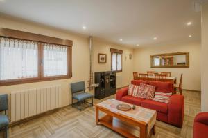 a living room with a red couch and a table at Torres 1 in Quintana de Valdivielso