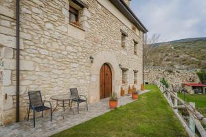 a stone building with a table and chairs in a yard at Torres 1 in Quintana de Valdivielso