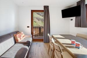a living room with a dining room table and a television at Chalet Serenella in Valdidentro