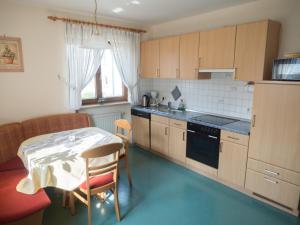 a kitchen with a table and a table and a chair at Ferienhof Henn in Weikersheim