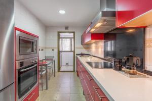 a large kitchen with red and white cabinets and appliances at Central, Spacious Parking in Granada