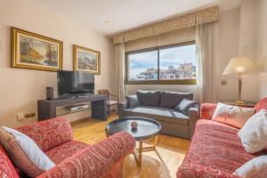 a living room with a couch and a tv at Central, Spacious Parking in Granada