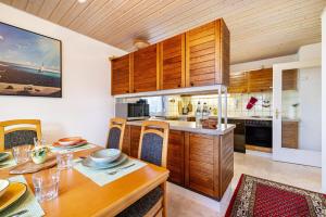 a kitchen with wooden cabinets and a wooden dining table at Hund und Kind Appartment in Oberndorf am Neckar