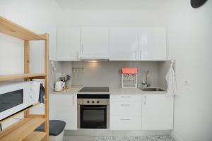 a small kitchen with white cabinets and a stove at El Rincón de Mónica in Agaete