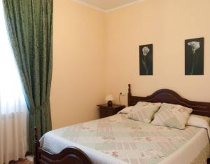 a bedroom with a bed with a green curtain at Casa Rural Vielba in Barruelo de Santullán