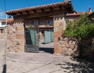a stone house with a gate in front of it at Casa Rural Vielba in Barruelo de Santullán