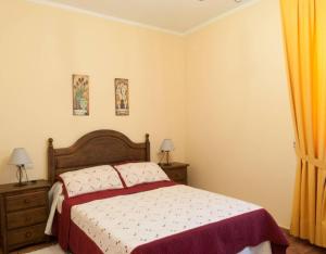 a bedroom with a bed and two night stands and two lamps at Casa Rural Vielba in Barruelo de Santullán +3 photos