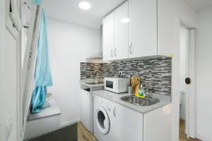 a kitchen with a sink and a washing machine at Casa Paula - 13 in Arinaga +13 photos