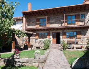 an old stone house with a walkway in front of it at Casa Rural Vielba in Barruelo de Santullán