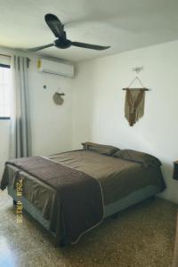a bedroom with a bed and a ceiling fan at Casa Rouge Alojamiento Cerca de Uman in Mérida