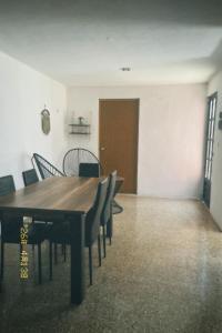a dining room with a wooden table and chairs at Casa Rouge Alojamiento Cerca de Uman in Mérida