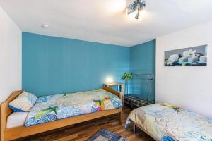 a bedroom with two beds and a blue wall at Alb Rose Ferienwohnung in Sonnenbühl