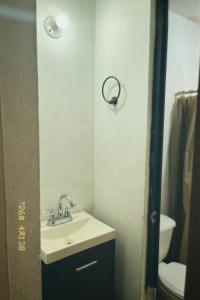 a bathroom with a sink and a toilet at Casa Rouge Alojamiento Cerca de Uman in Mérida