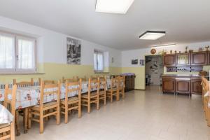 a dining room with tables and chairs and a kitchen at Casa Vacanza Zambotti in Vermiglio