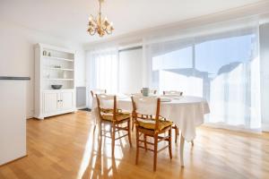 a dining room with a white table and chairs at Ty Corniche - 50m de la plage in Bénodet