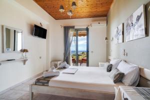 a bedroom with a large white bed and a balcony at Nontas Homes 32 in Kalamitsi