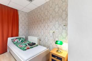 a small bedroom with a bed and a table with a lamp at Ferienwohnung bei Burg Eltz in Kaisersesch