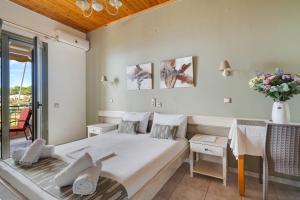a bedroom with a bed and a table and chairs at Nontas Homes 32 in Kalamitsi