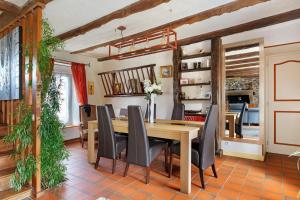 a dining room with a wooden table and chairs at Chambre Grany - Chambre in Aucaleuc +11 photos