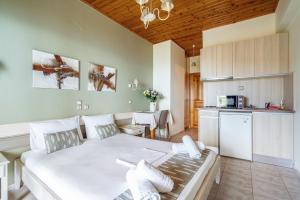 a living room with a white bed and a kitchen at Nontas Homes 32 in Kalamitsi