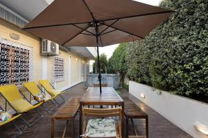 a table with chairs and an umbrella on a patio at Douro Garden House and Pool in Vila Nova de Gaia