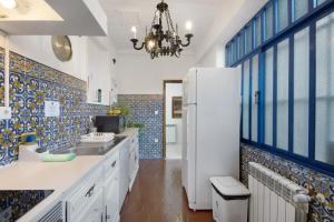 a kitchen with a white refrigerator and blue tiles at Douro Garden House and Pool in Vila Nova de Gaia +26 photos